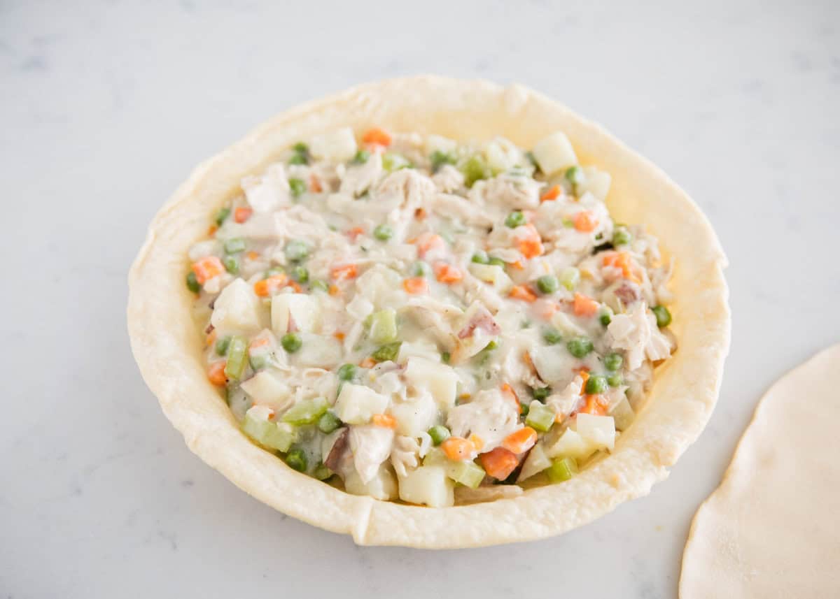 Unbaked turkey pot pie filling in a pie crust.