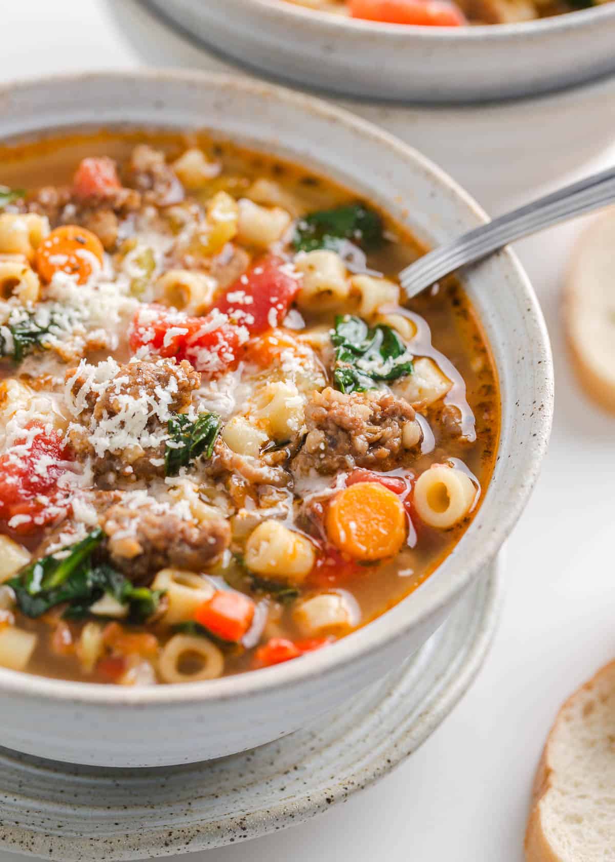 Italian sausage soup in a bowl garnished with Parmesan.