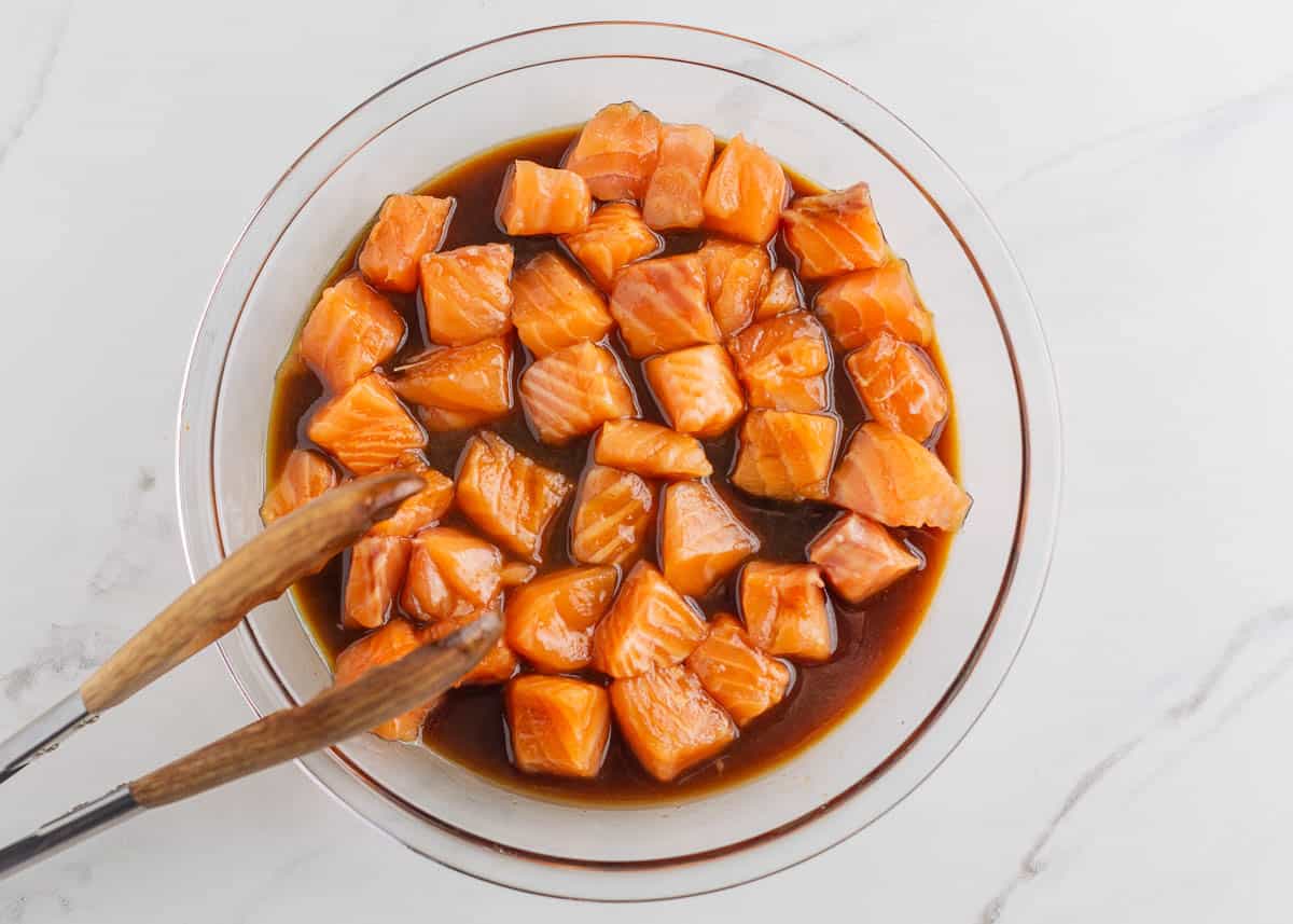 Salmon bites marinating in a bowl.