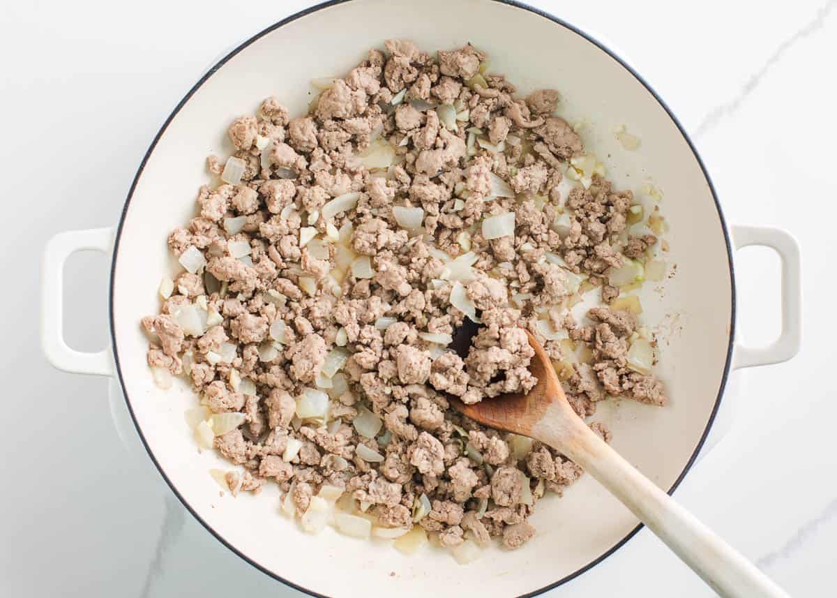 Ground beef and onion browning in a skillet.