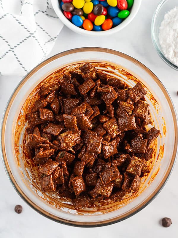 Chex in a bowl coated in peanut butter chocolate mixture.