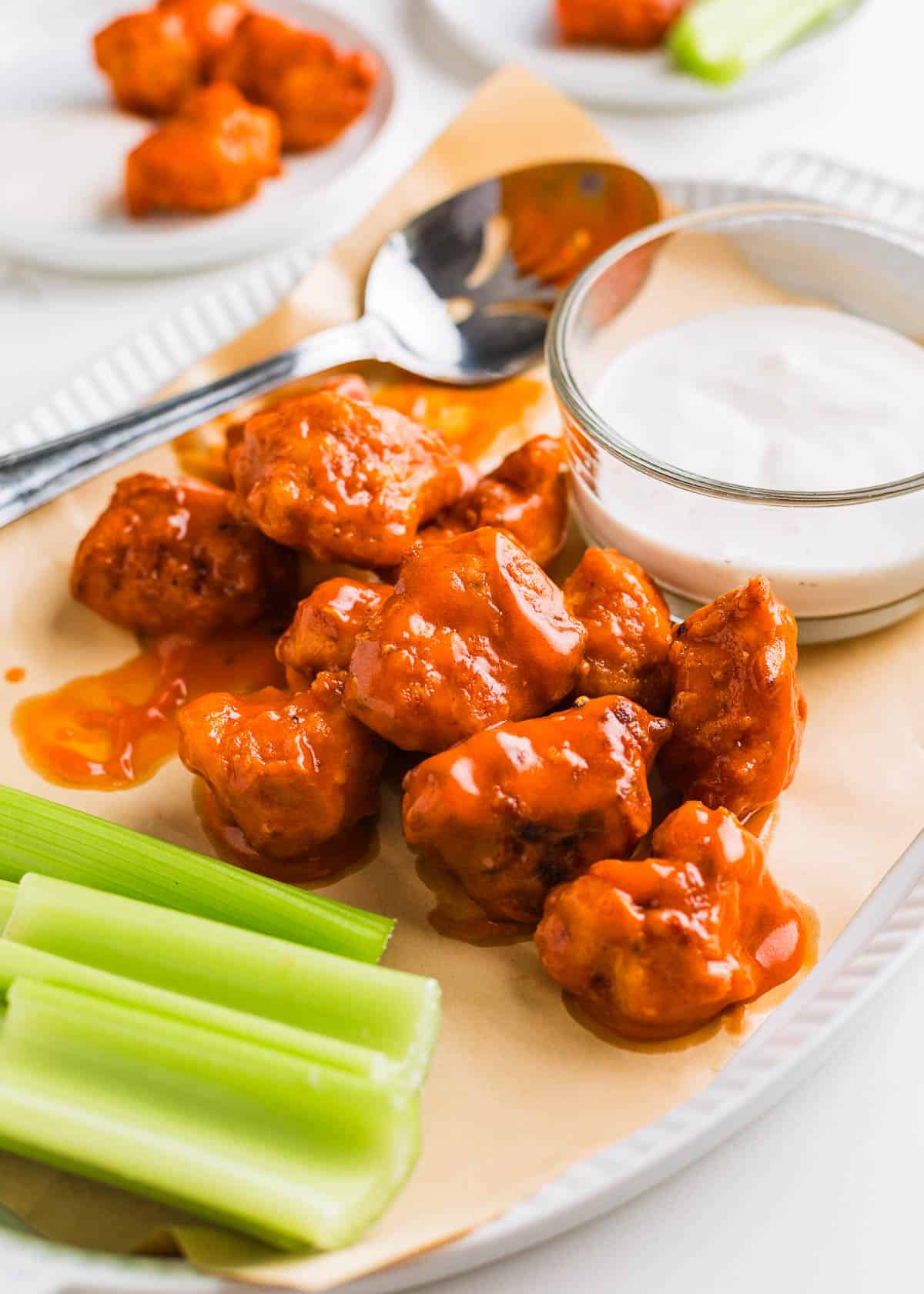 Boneless wings on a serving plate covered with sauce.