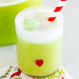 Grinch punch in a glass cup.