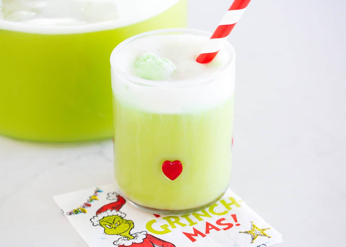 Grinch punch in a glass cup.