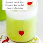 Grinch punch in a glass with ingredients listed.