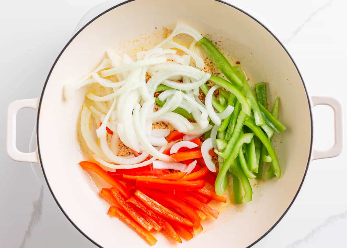 Peppers and onion in a skillet.