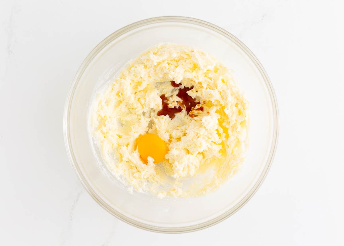 Creamed butter and sugar in a bowl with egg yolk and vanilla.