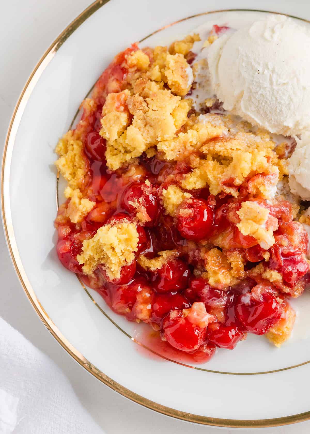 Cherry dump cake on a white plate.