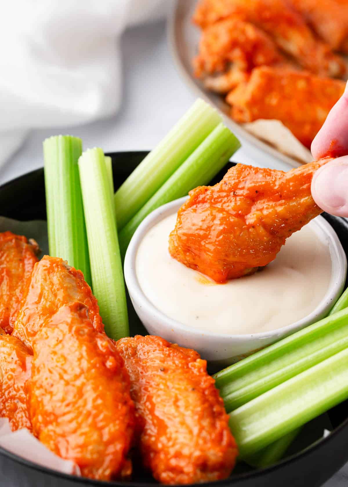 Dipping an oven baked buffalo wing into sauce. 