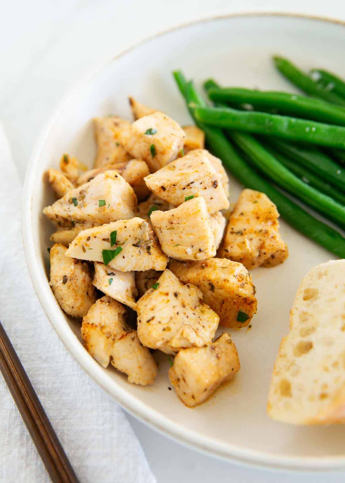 Baked chicken bites on a plate with sides.