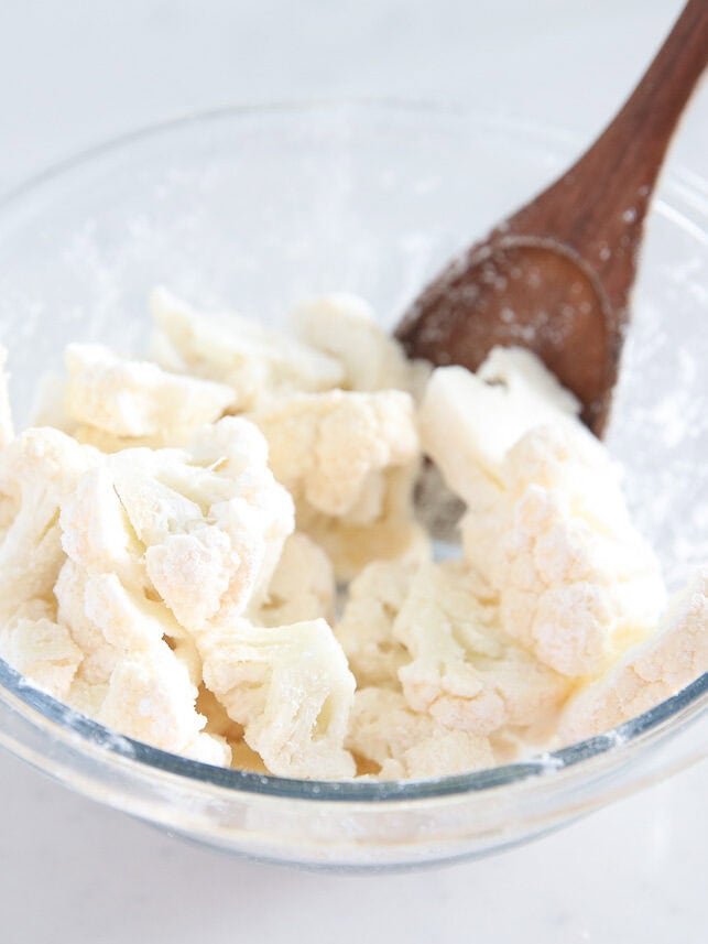 Stirring cauliflower in a bowl.