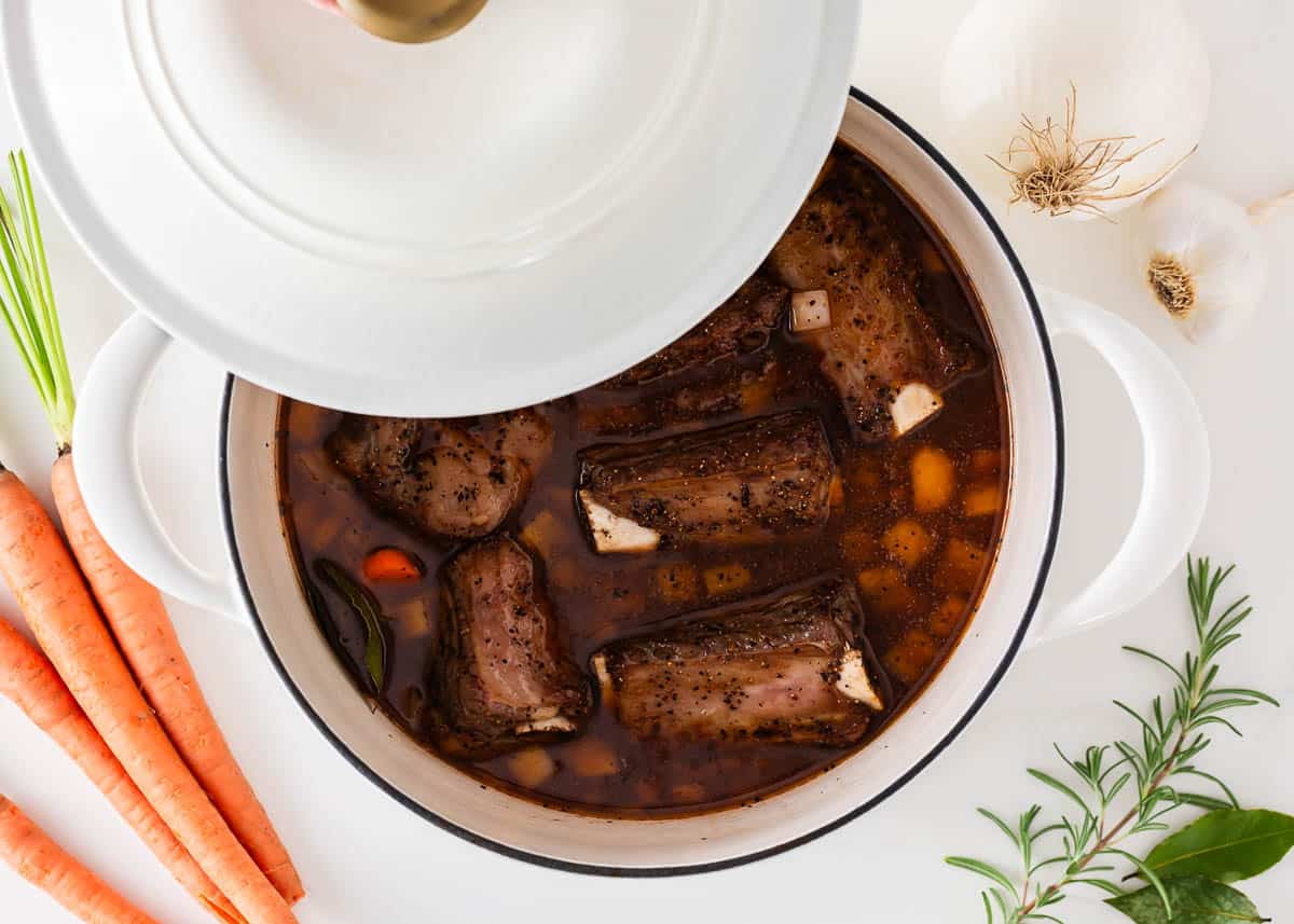 Covering the Dutch oven with a lid for braised short ribs.