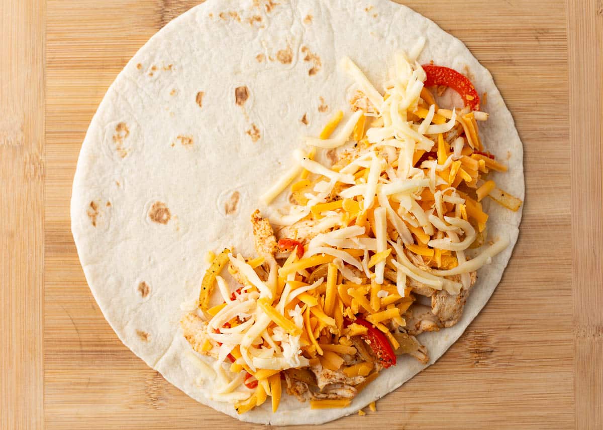 Chicken, peppers, onion and cheese on a tortilla.