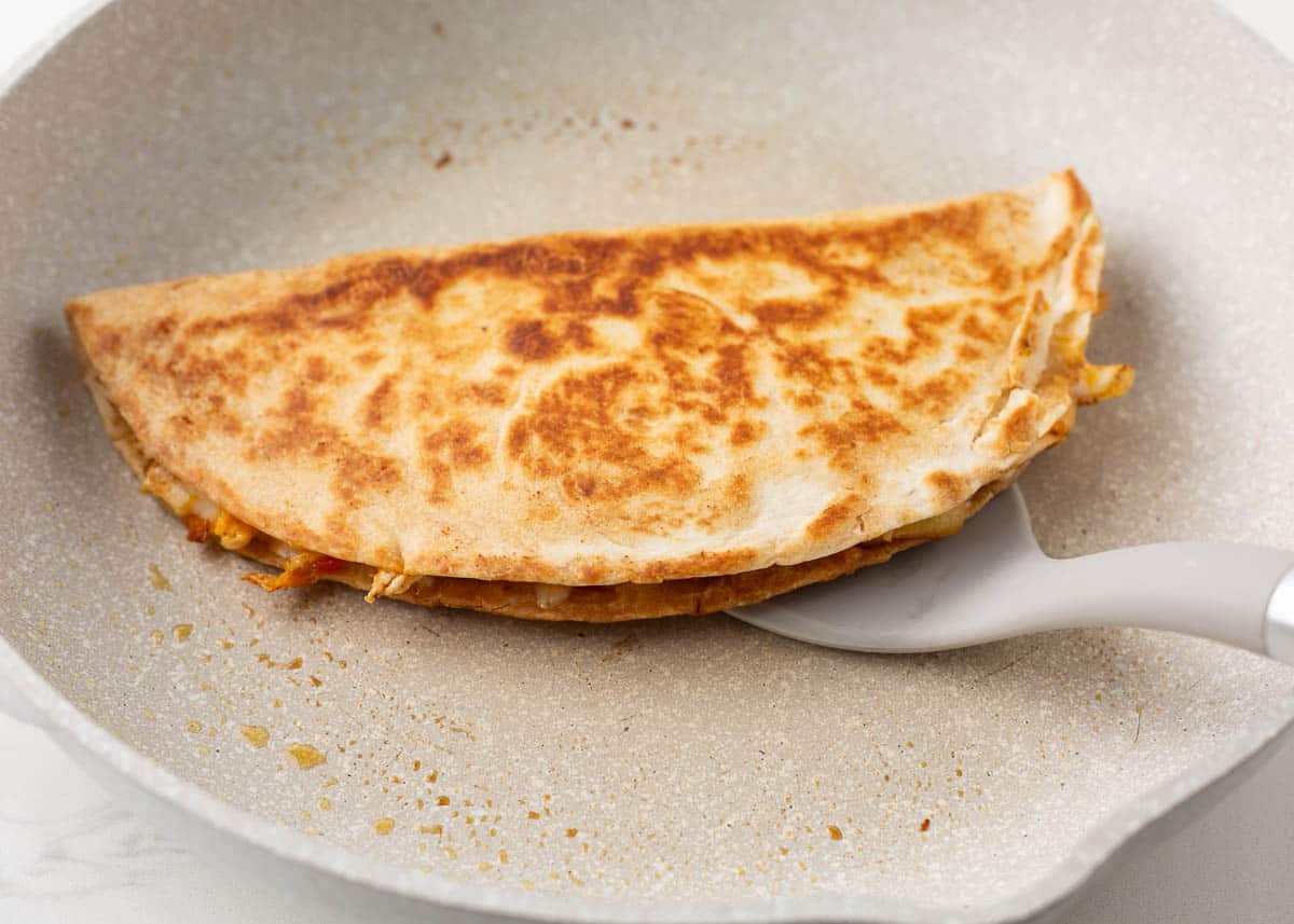 Cooking quesadilla in a skillet.