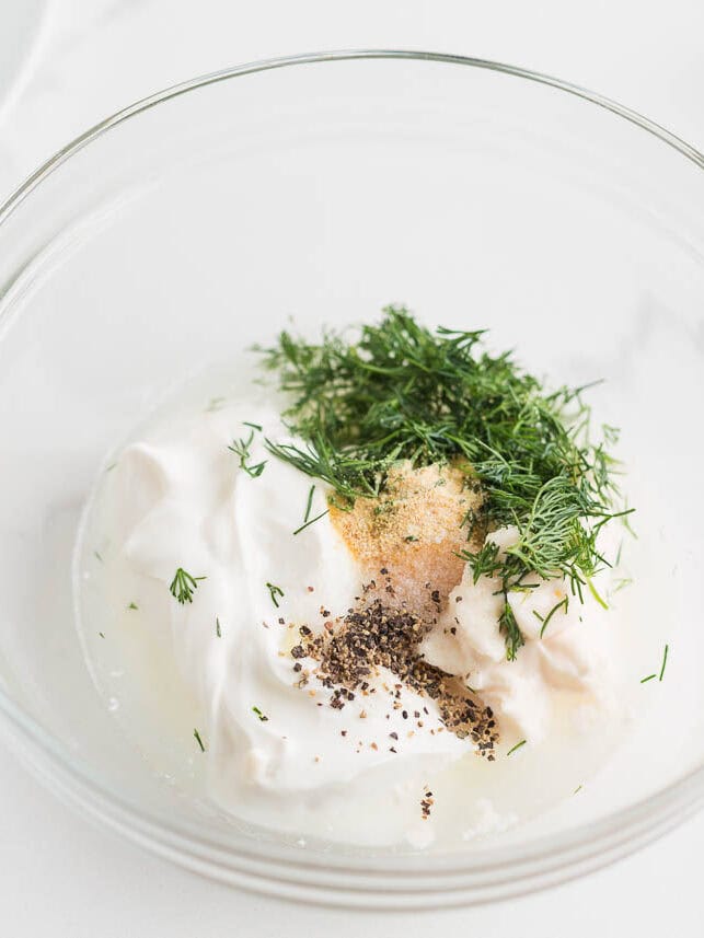 Mayo, sour cream, dill, garlic powder and pepper in a bowl.