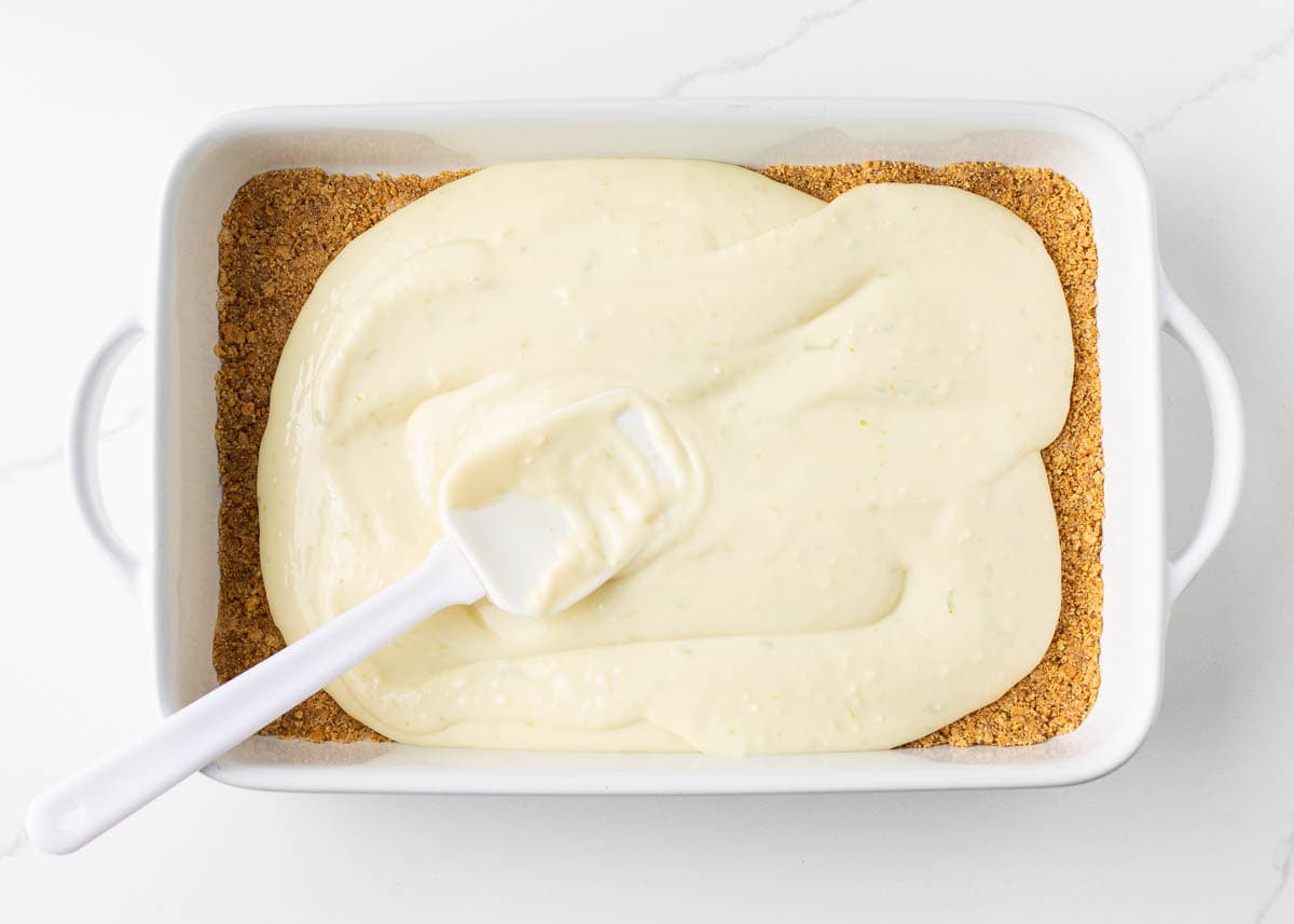 Spreading key lime pie filling onto crust.