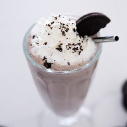 Oreo milkshake in a glass cup.