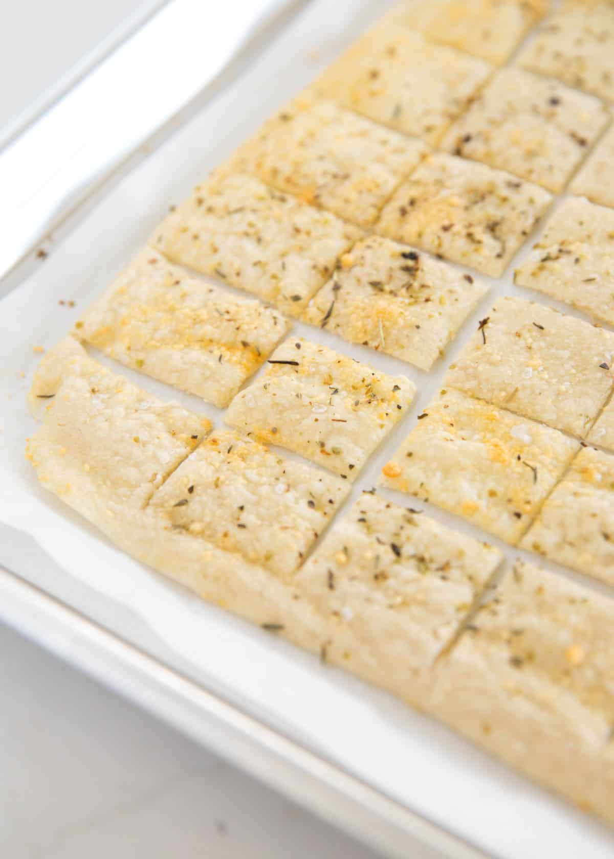 Sourdough dsicard crackers on a baking sheet.