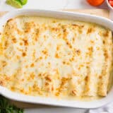 White chicken enchiladas in baking dish.