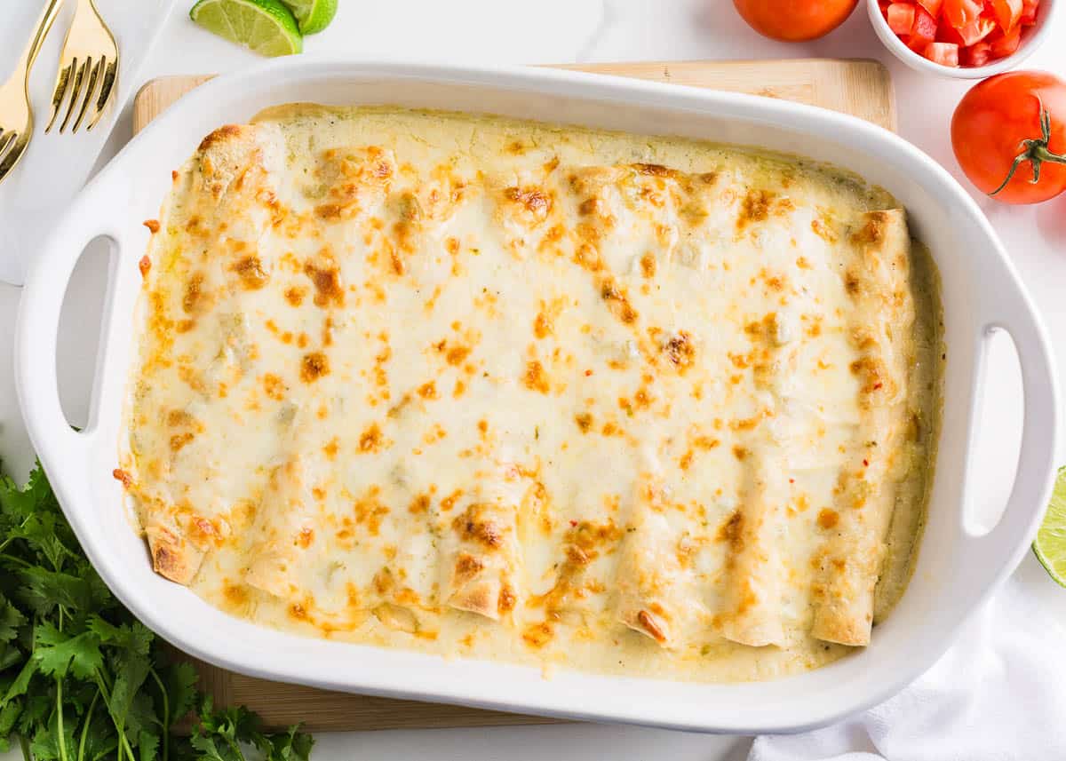 White chicken enchiladas in baking dish. 