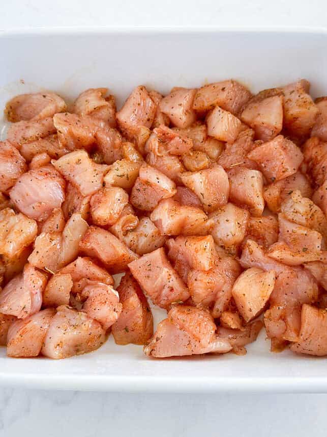 Raw chicken bites in a baking dish.